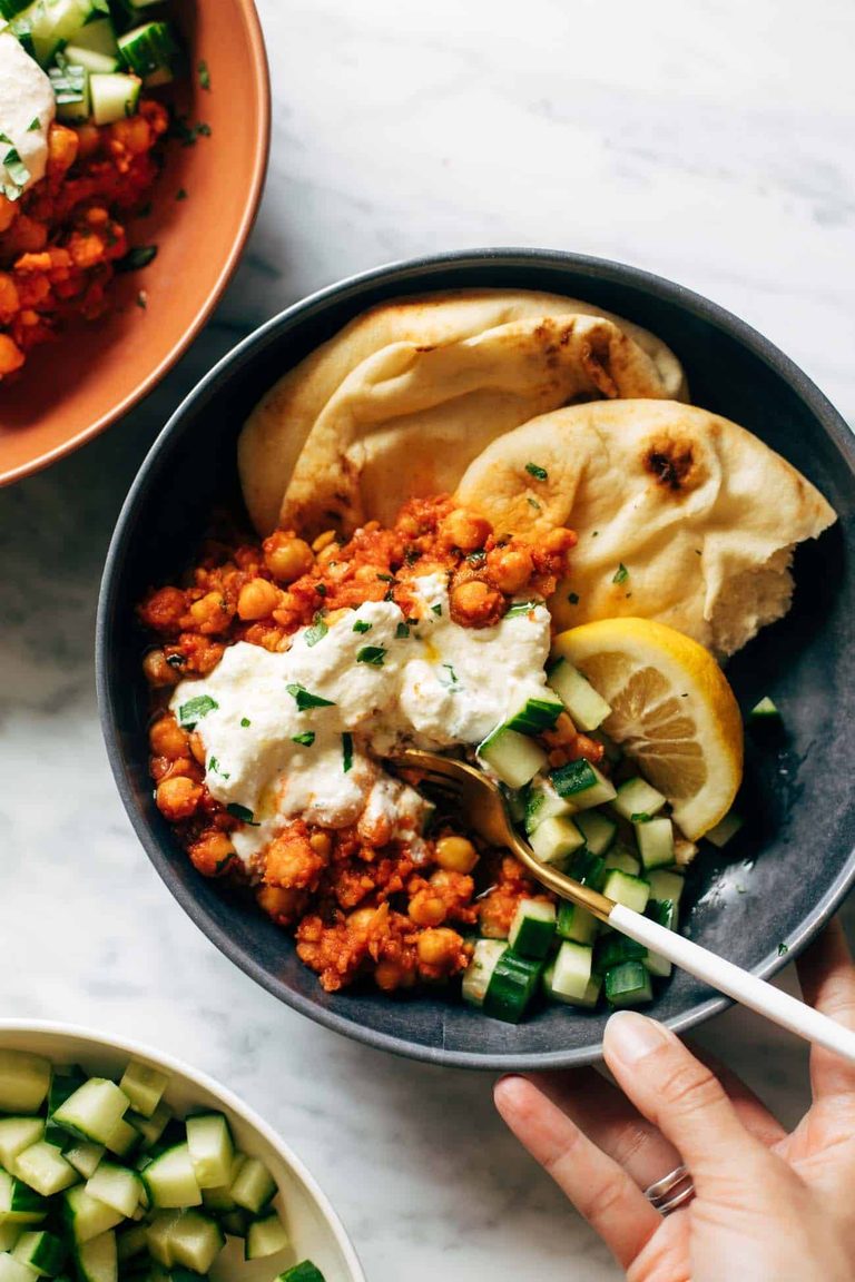 Harissa chickpeas in a bowl with whipped feta and naan.
