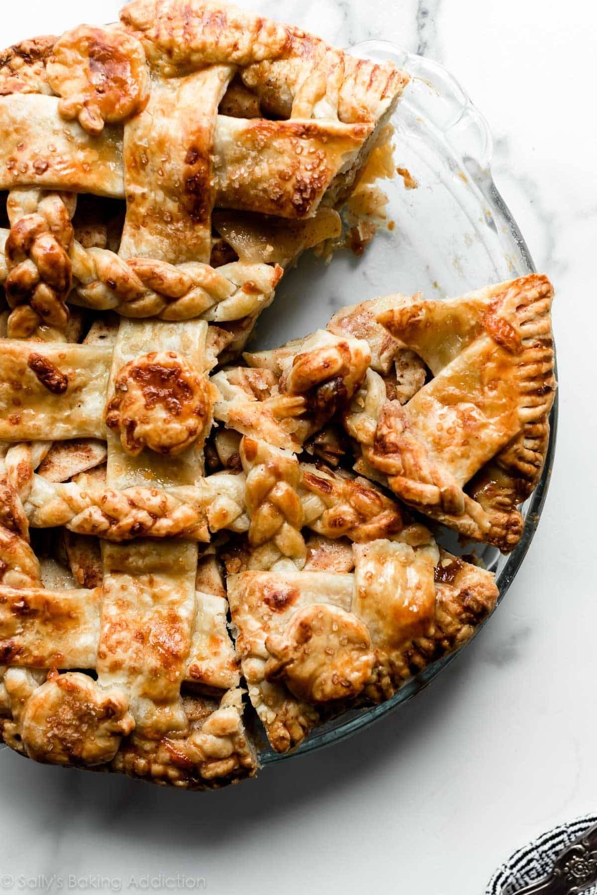 Apple Cheddar Pie in a pie dish with a piece missing