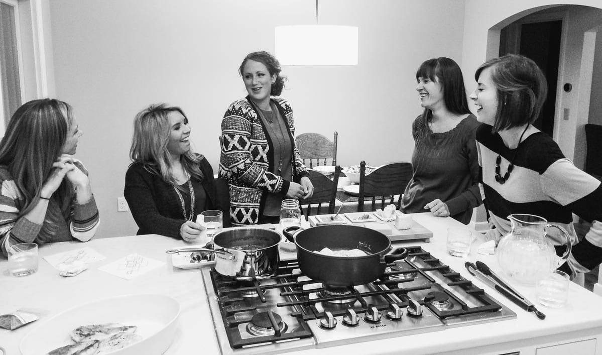 Black and white photo of people in a kitchen.